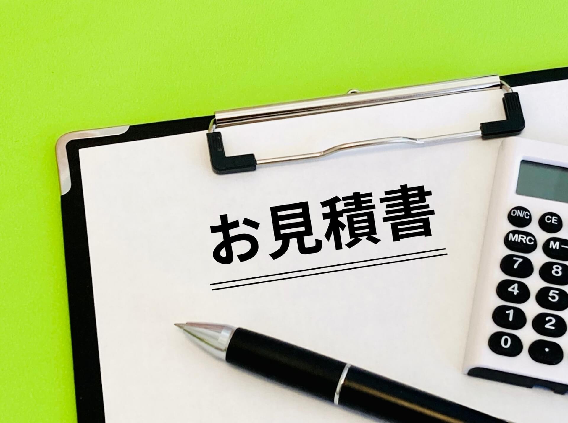 クリップボードに置かれたお見積書と電卓